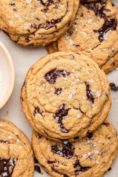 A few brown butter chocolate chip cookies on parchment paper.
