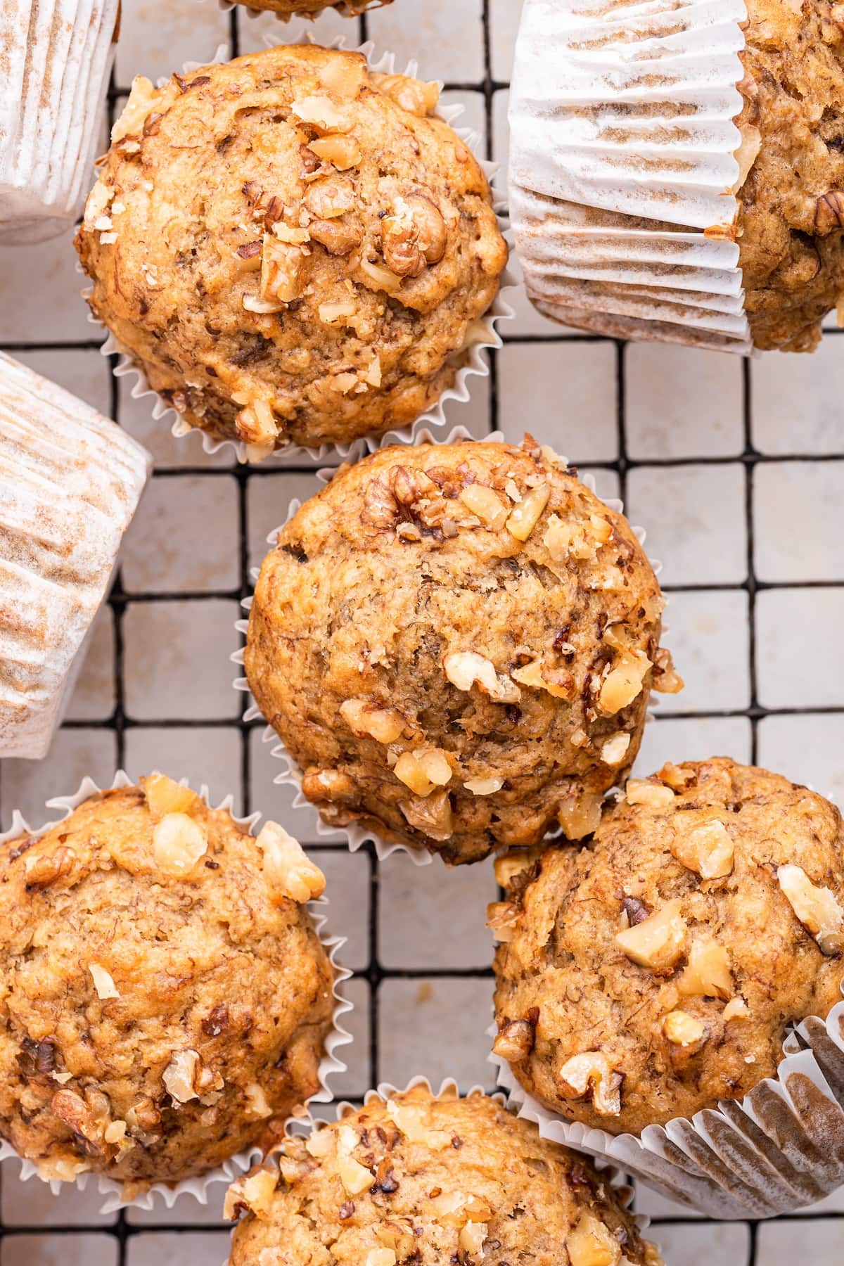 Multiple banana muffins near one another on a cooling rack.