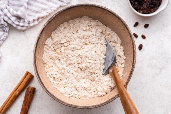 A large mixing bowl of dry ingredients used for oatmeal raisin cookies.