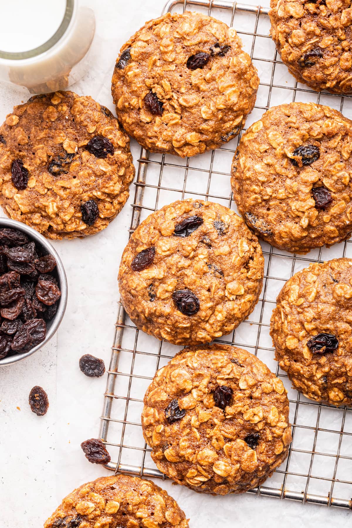 Multiple oatmeal raisin cookies on a cooling rack.