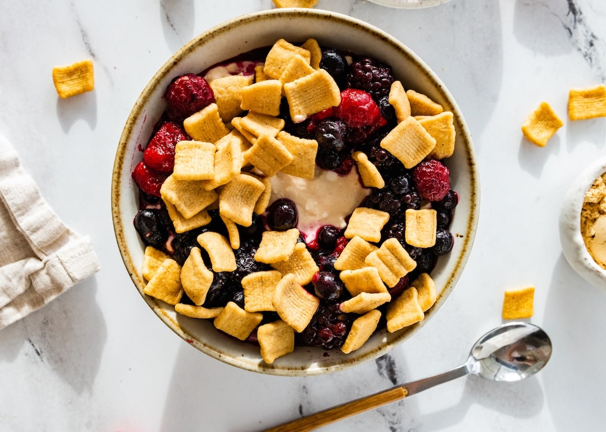 PB&J protein yogurt bowl with frozen berries and Catalina Crunch as toppings.