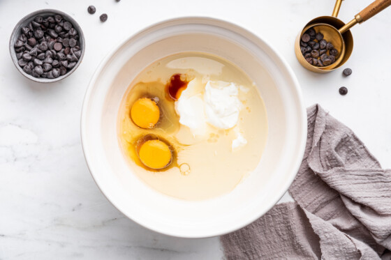 All the wet ingredients used for a protein cake in a large mixing bowl.