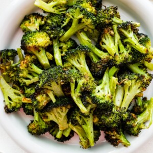 Roasted broccoli on a white plate.