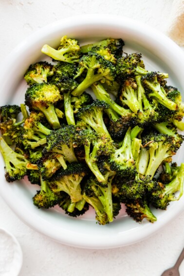 Roasted broccoli on a white plate.