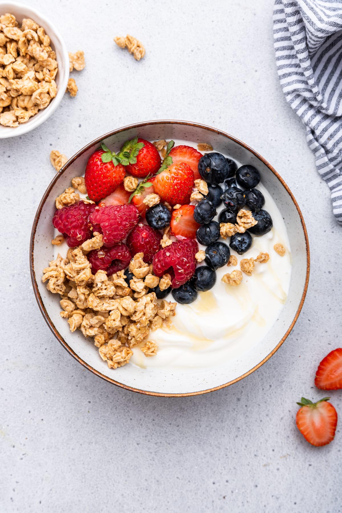 A yogurt bowl topped with granola and fresh strawberries, blueberries and raspberries.