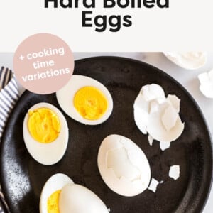 Hard boiled eggs being peeled on a plate.