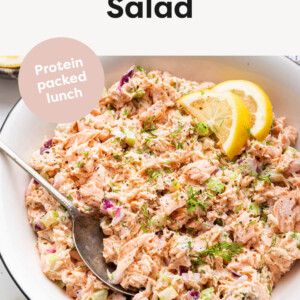 Salmon Salad in a bowl with lemon slices and a spoon.