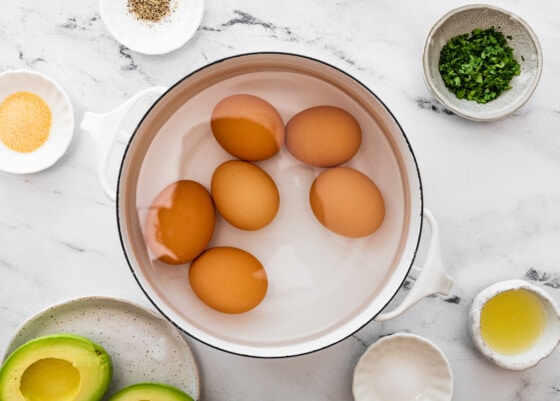 Six eggs in a large pot of water.