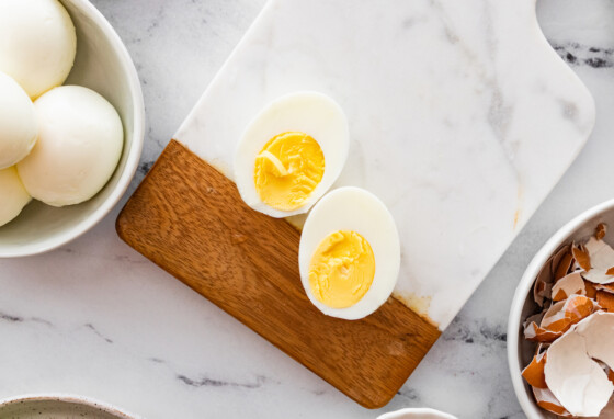 A hard boiled eg split in half on a cutting board.