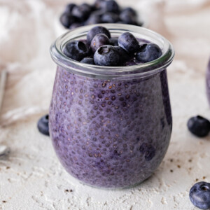Blueberry chia pudding in a glass cup topped with fresh blueberries.