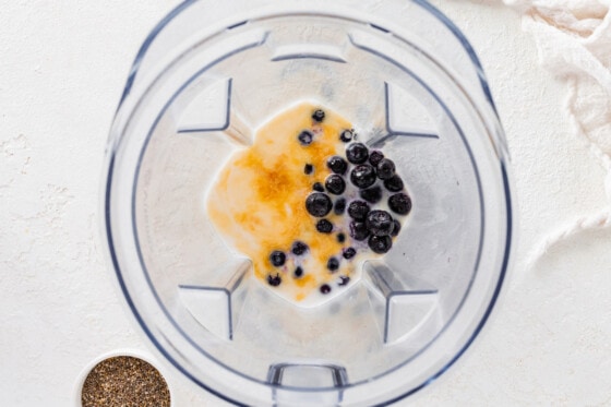 Blueberries, milk, maple syrup, and vanilla in a blender.