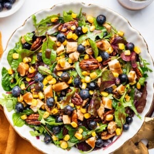 Mixed blueberry corn chicken salad served with dressing.