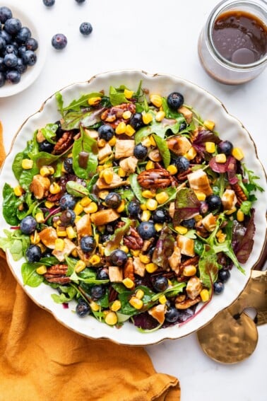 Mixed blueberry corn chicken salad served with dressing.