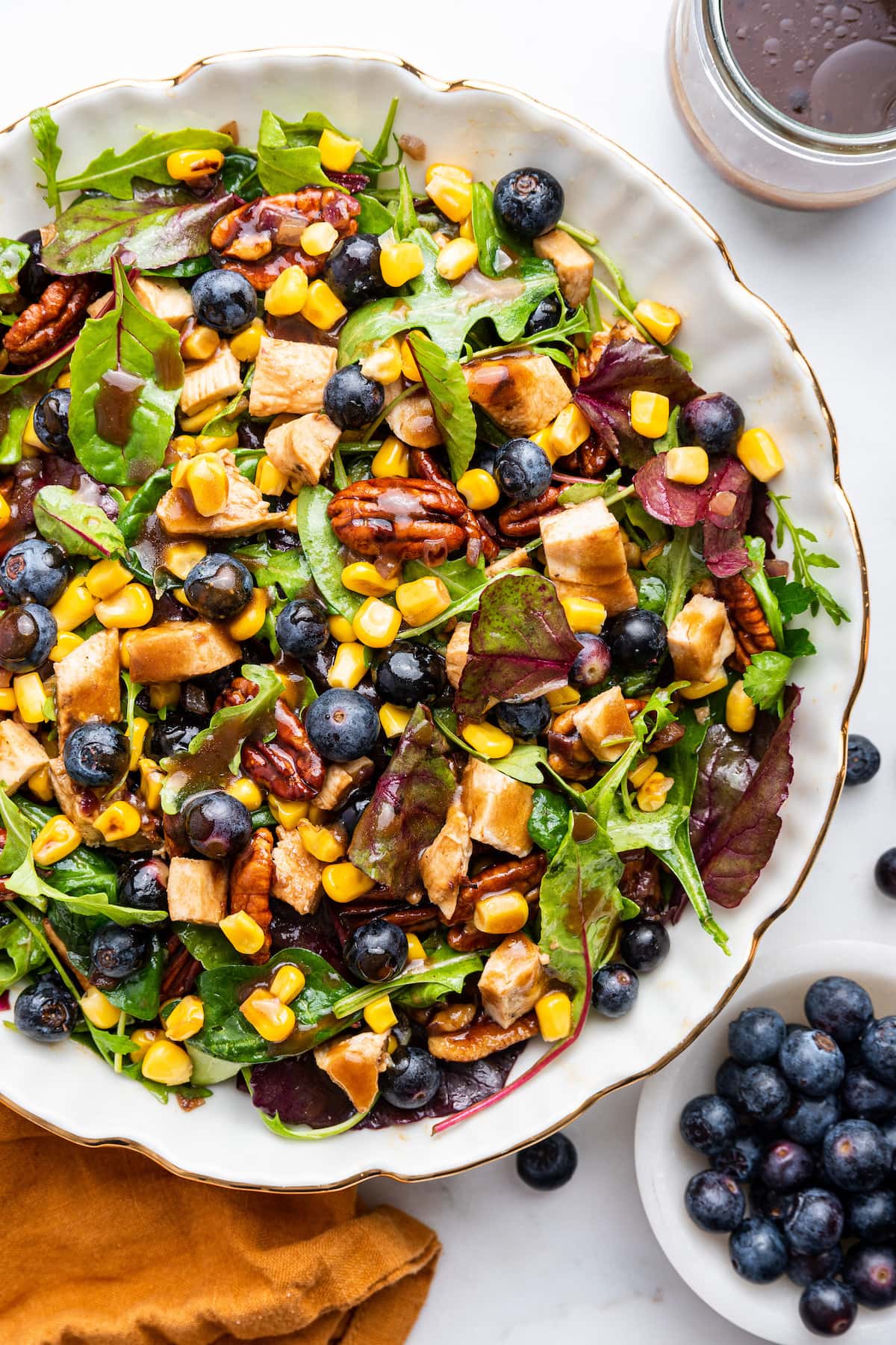 Mixed blueberry corn chicken salad served with dressing.
