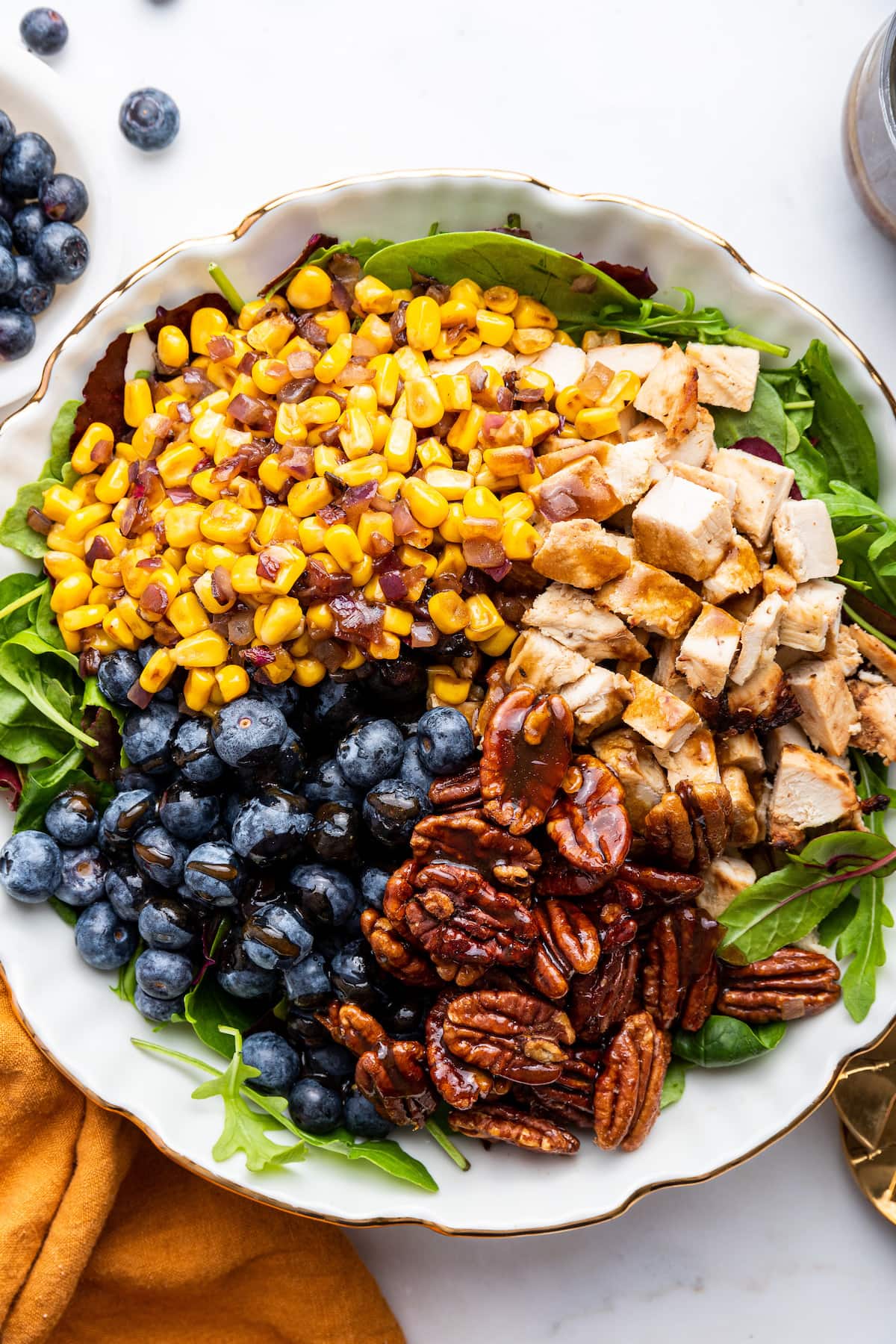 Ingredients for the blueberry corn chicken salad served over a bed of greens.