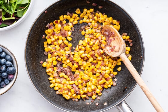 Corn cooking in a skillet for the blueberry corn chicken salad.