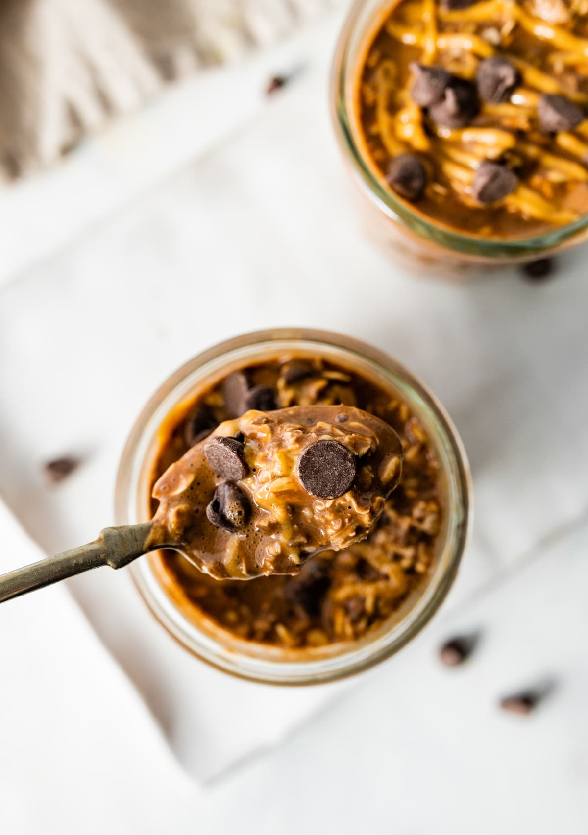 A spoonful of the chocolate overnight oats topped with chocolate chips.
