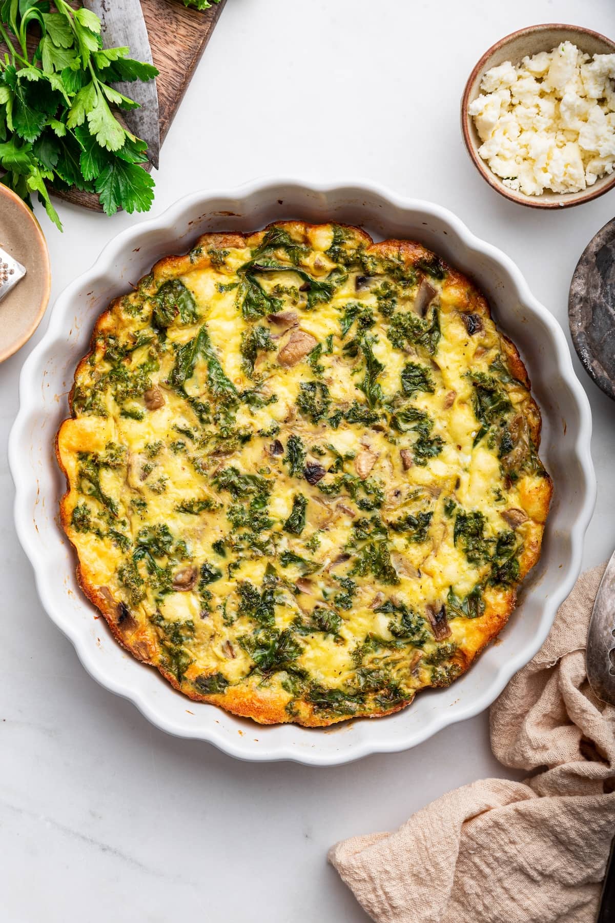 An unsliced crustless quiche in a pie plate.