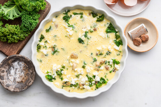 An unbaked crustless quiche in a pie plate.