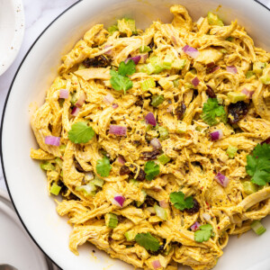 Curry chicken salad in a white bowl.