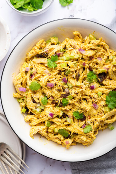 Curry chicken salad in a white bowl.