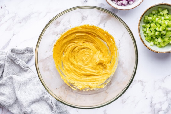 A yellow curry paste in a glass bowl.