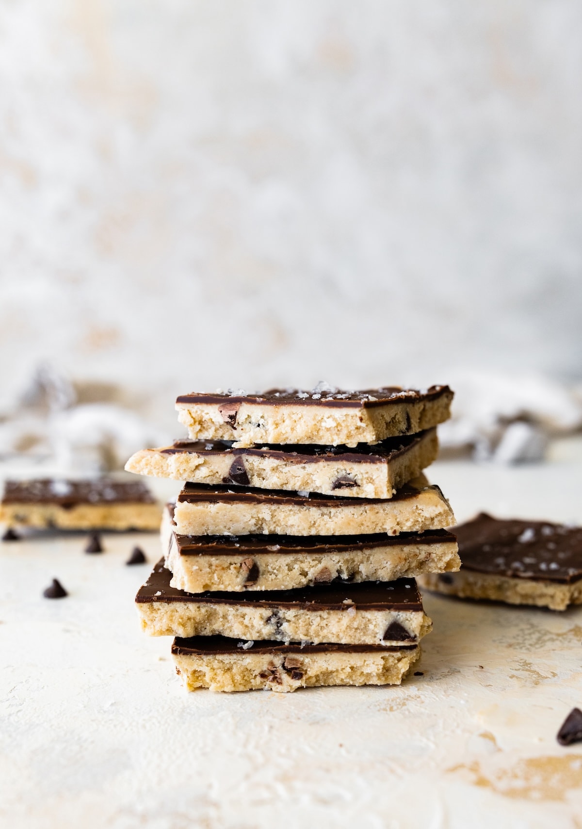 Six protein cookie dough bark pieces stacked on top of each other.
