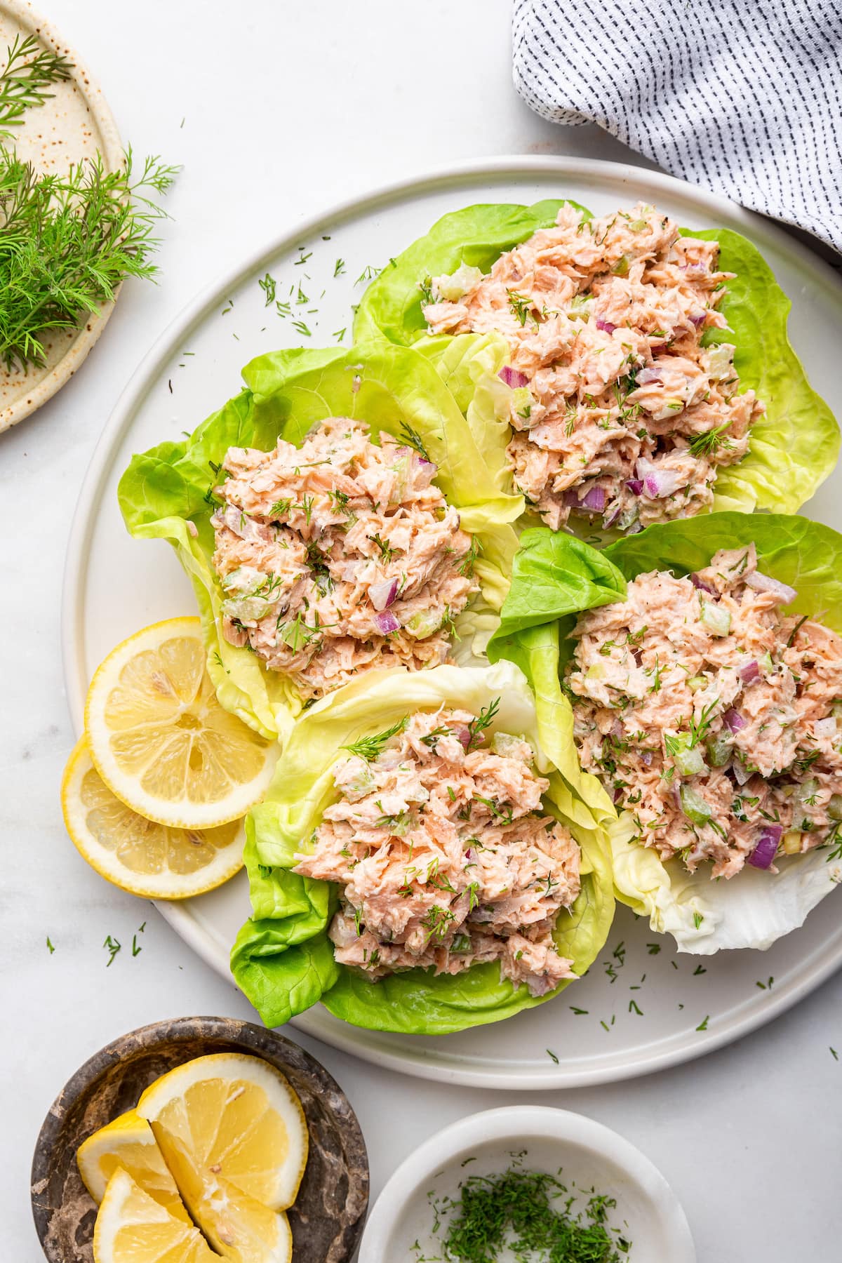 Four lettuce leaves containing salmon salad on a plate.