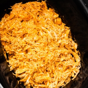 Shredded buffalo chicken in a slow cooker.