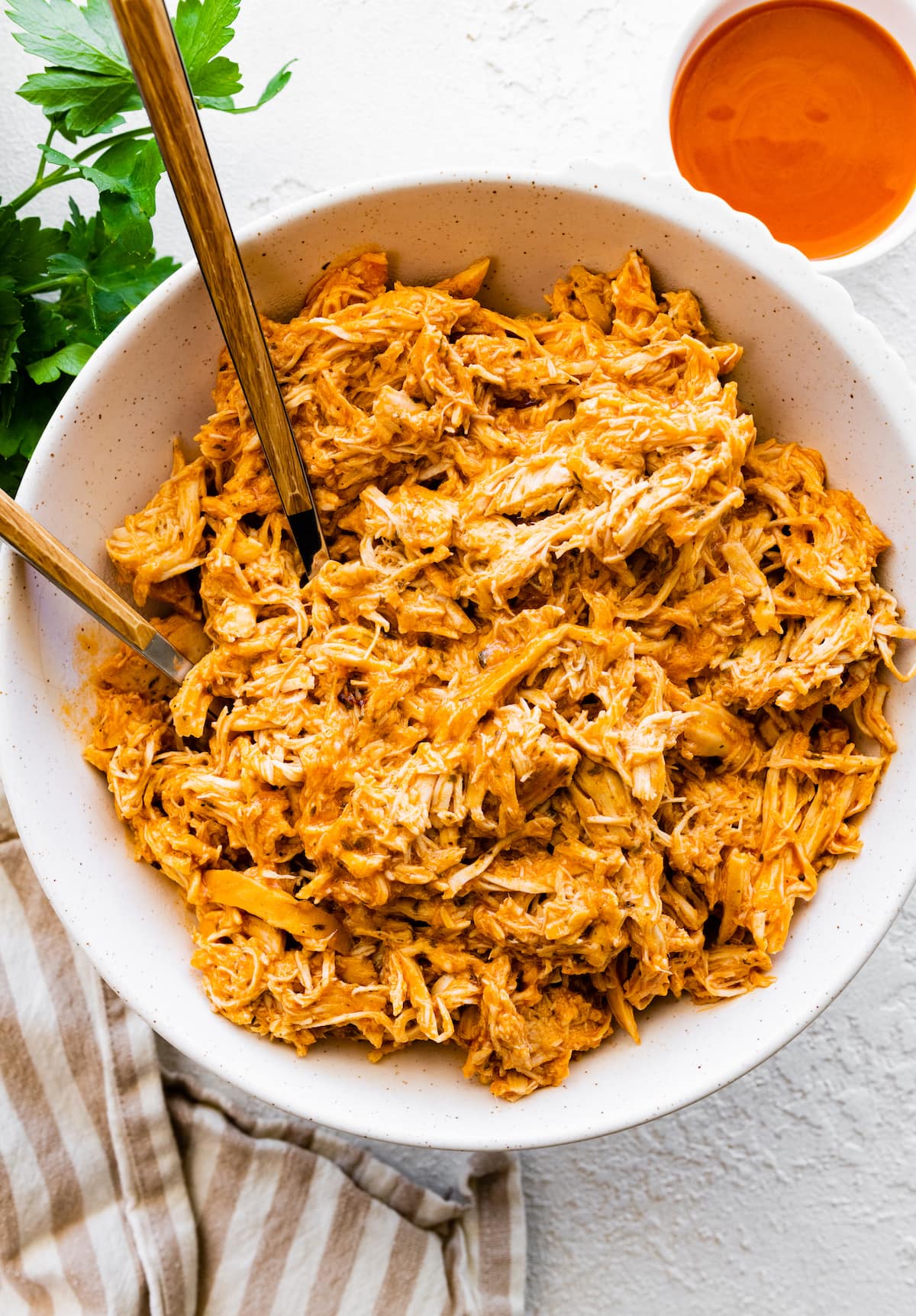 Slow cooked shredded buffalo chicken in a bowl.