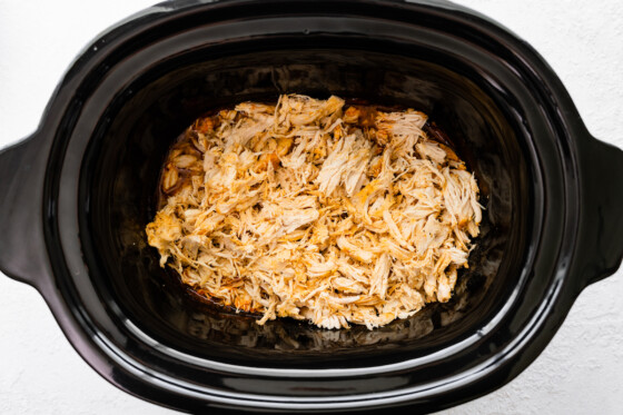 Shredded buffalo chicken in a slow cooker.