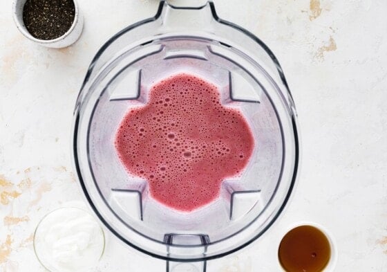 Strawberries and milk blended in a blender.