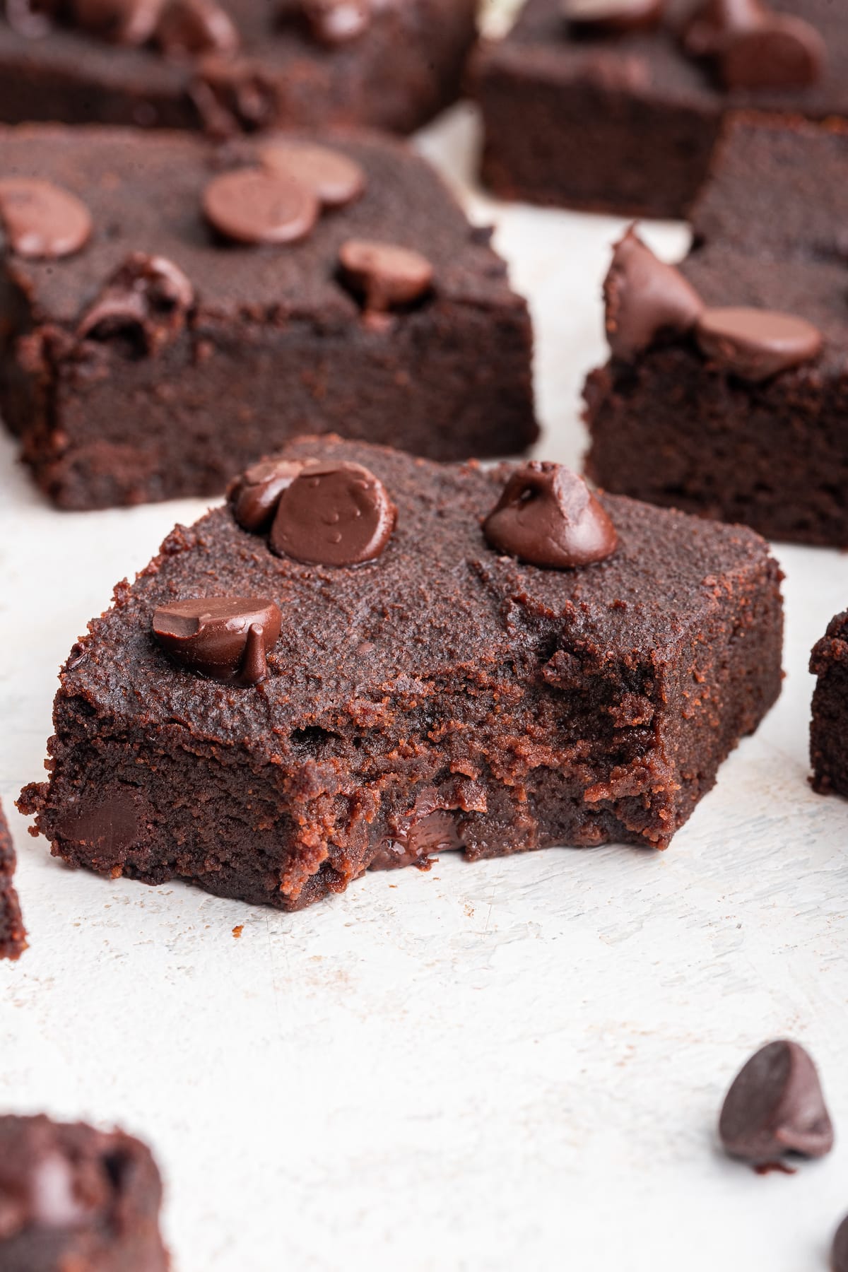 A chocolate chip sweet potato brownie with a bite taken from it.