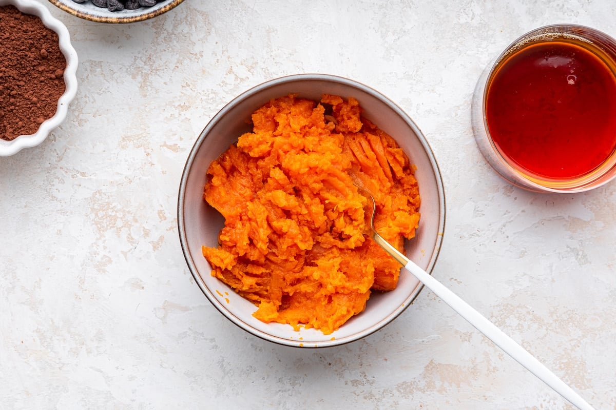 Mashed sweet potato in a bowl with a fork.