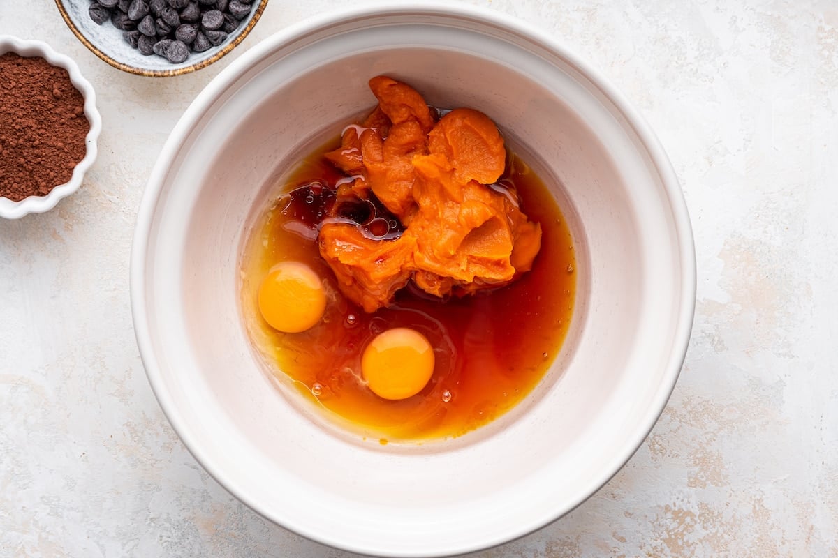 Mashed sweet potato, egg, oil, maple syrup, and vanilla in a mixing bowl.