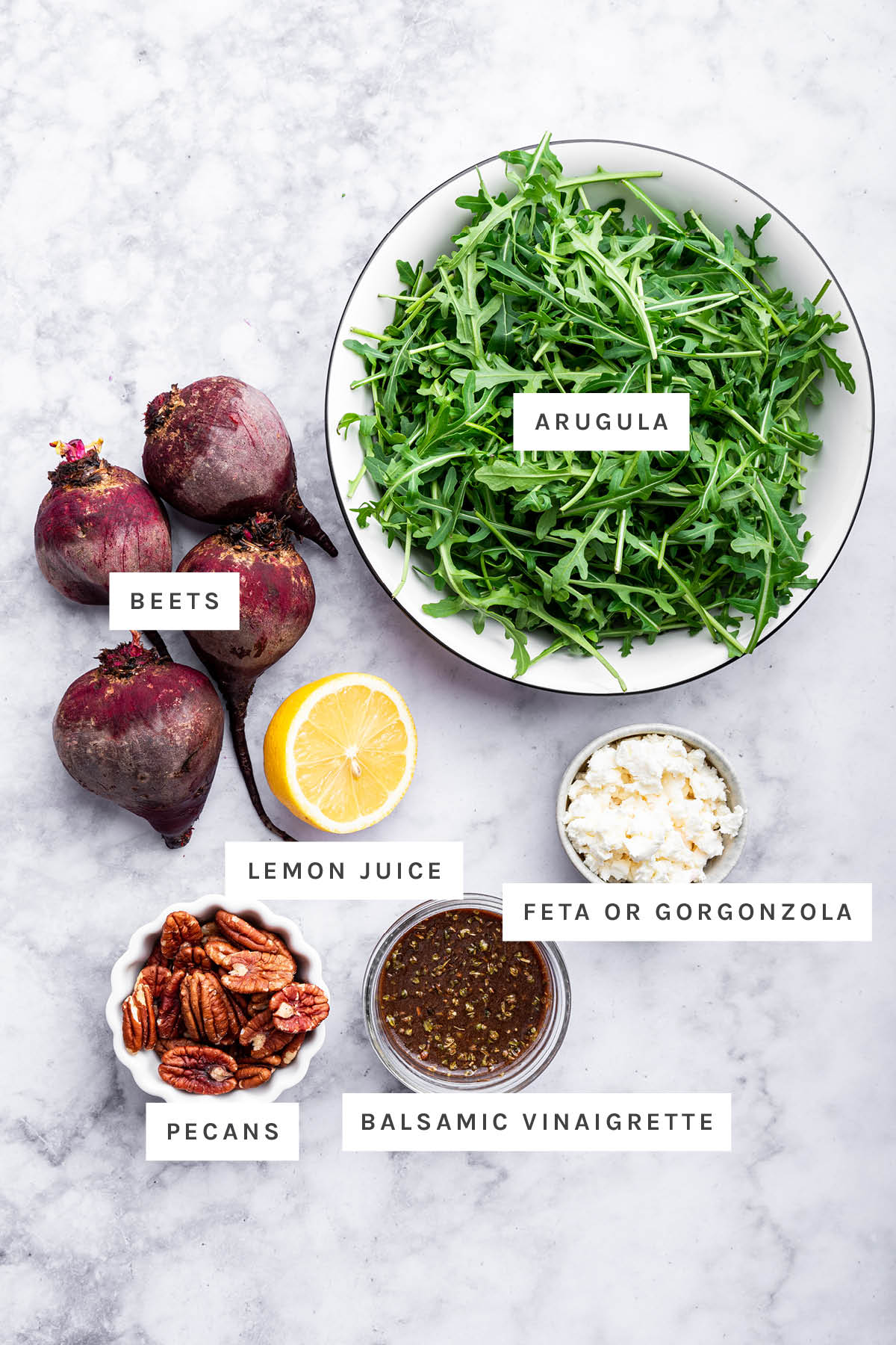 Ingredients measured out to make Beet Salad: beets, arugula, lemon juice, feta, pecans and balsamic vinaigrette.
