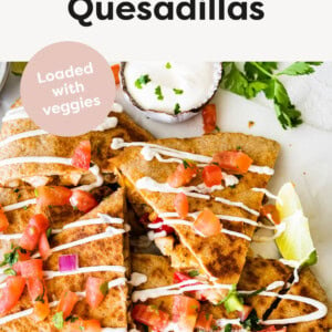 Healthy Chicken Quesadillas cut into triangles and topped with sour cream and tomato.