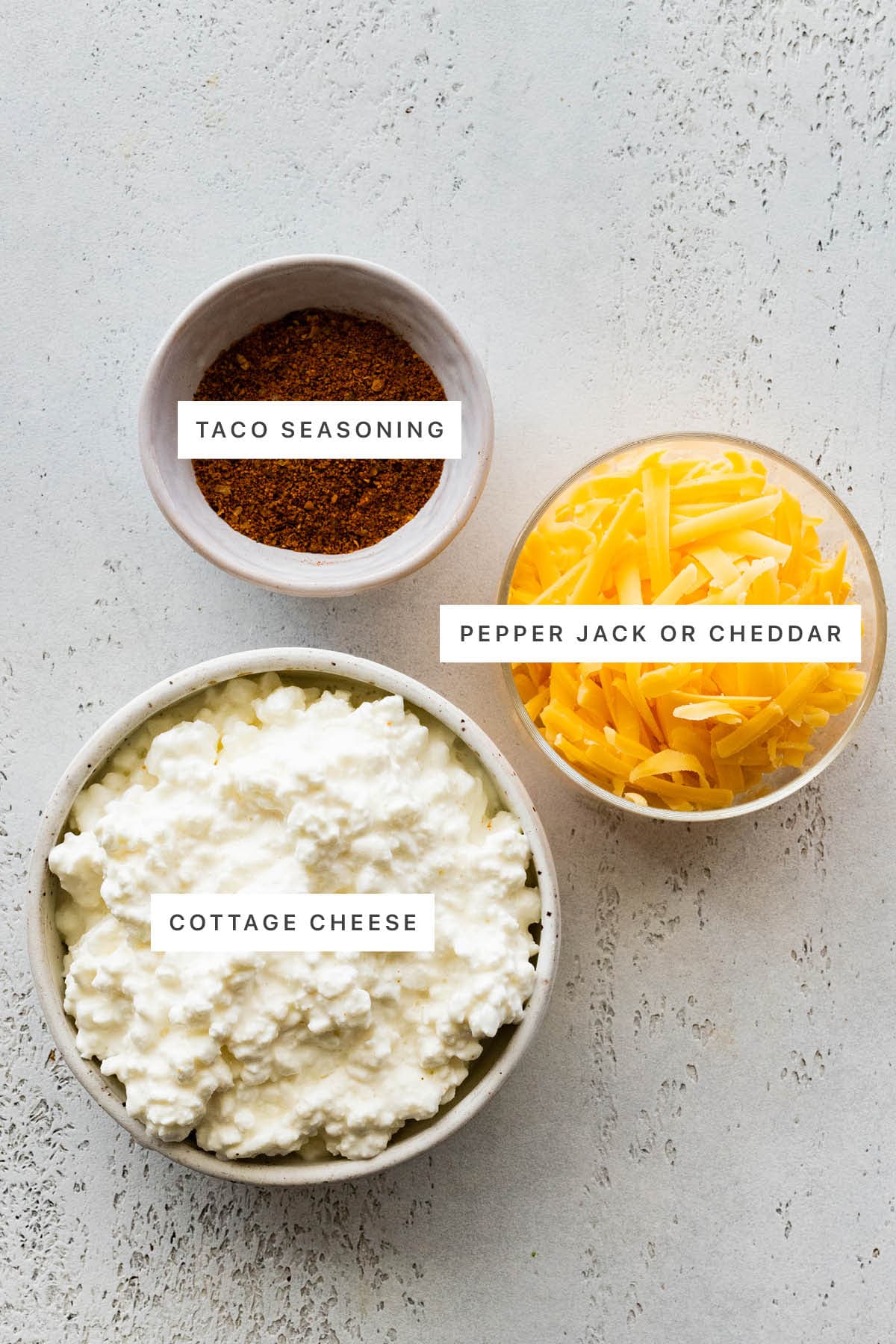 Ingredients measured out to make Cottage Cheese Queso: taco seasoning, cheddar cheese and cottage cheese.