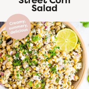 Mexican Street Corn Salad in a bowl, topped with creamy dressing, cilantro and lime.