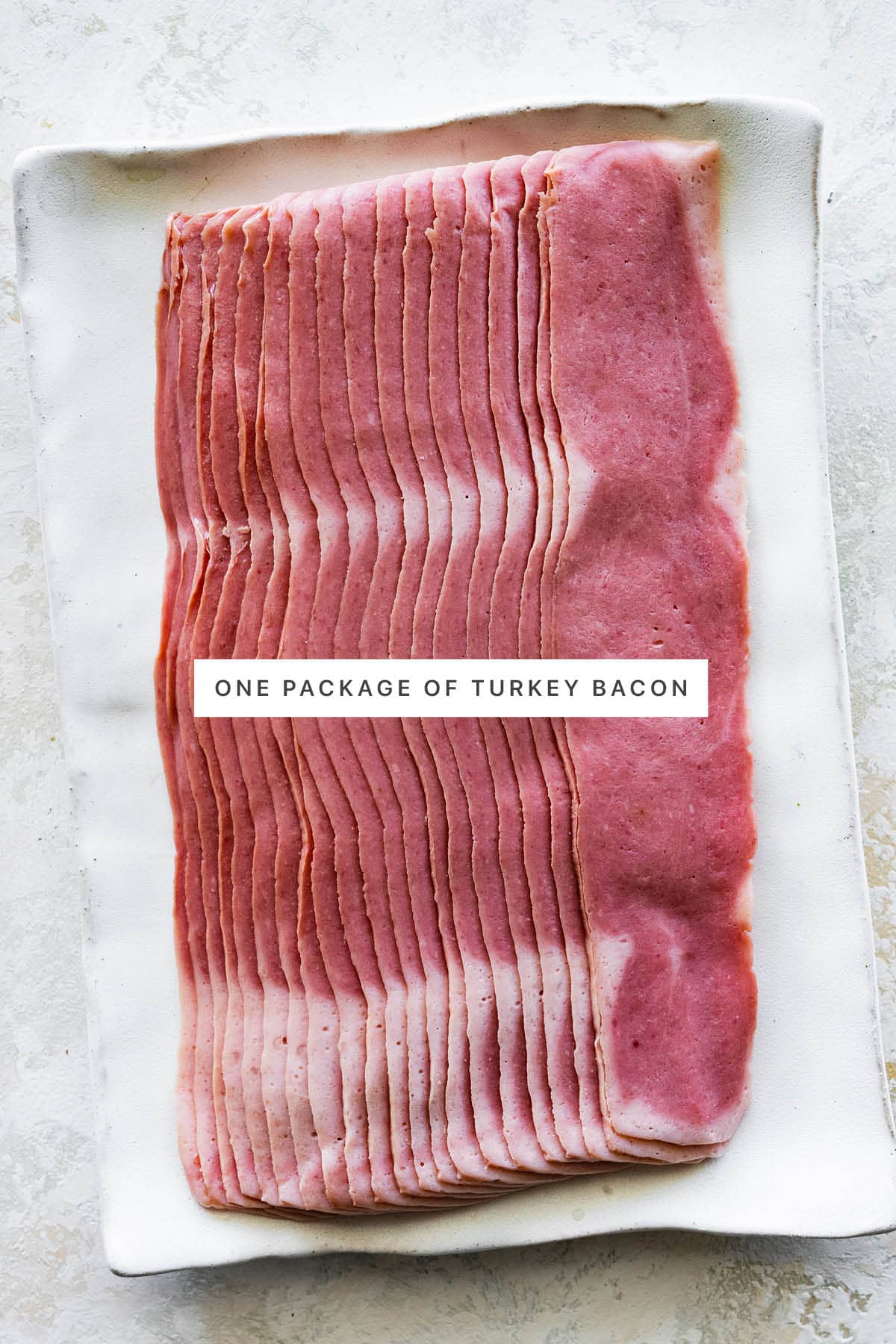 One package of uncooked turkey bacon on a platter.