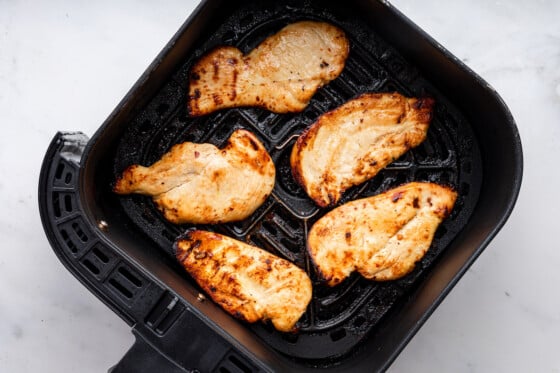 Five chicken cutlets cooked in an air fryer.