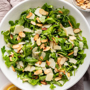 Arugula salad served in a white bowl.