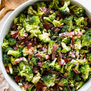 A broccoli salad in a large white bowl.