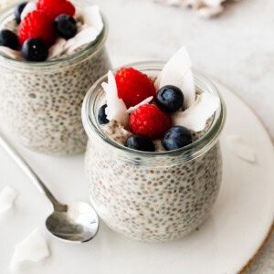 Coconut chia pudding in a glass cup, topped with fresh berries.