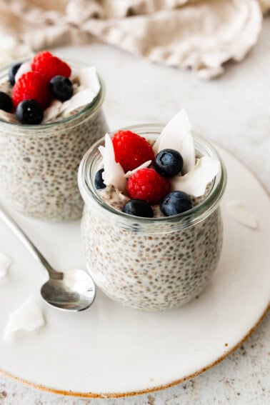 Coconut chia pudding in a glass cup, topped with fresh berries.