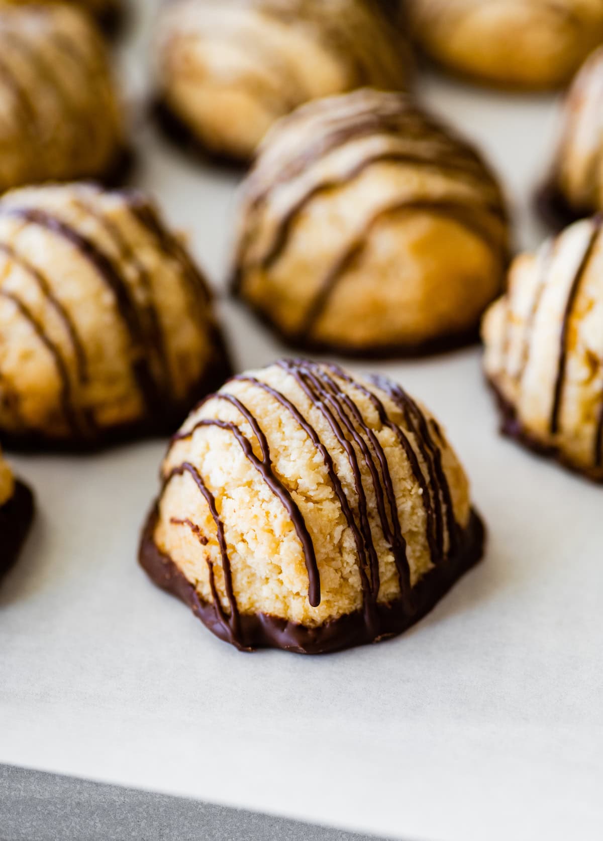 Coconut macaroons near one another on parchment paper.