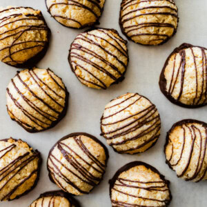 Multiple coconut macaroons near one another on parchment paper.