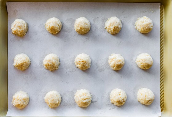 Coconut macaroon balls before being baked on a baking tray.