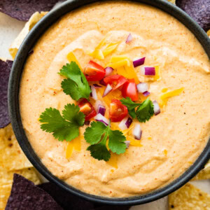 Cottage cheese queso in a small bowl with tortilla chips.