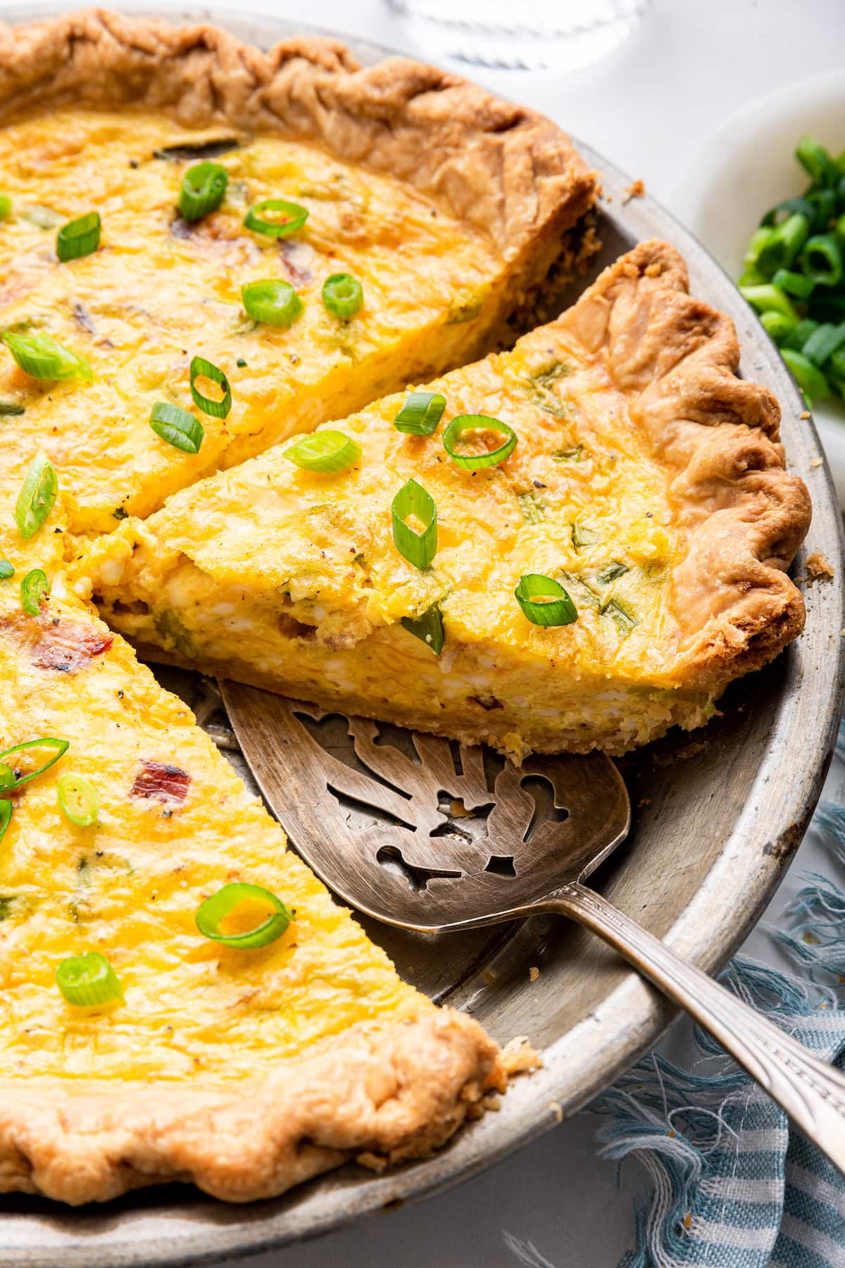 Cottage cheese quiche in a pan with a metal spatula.